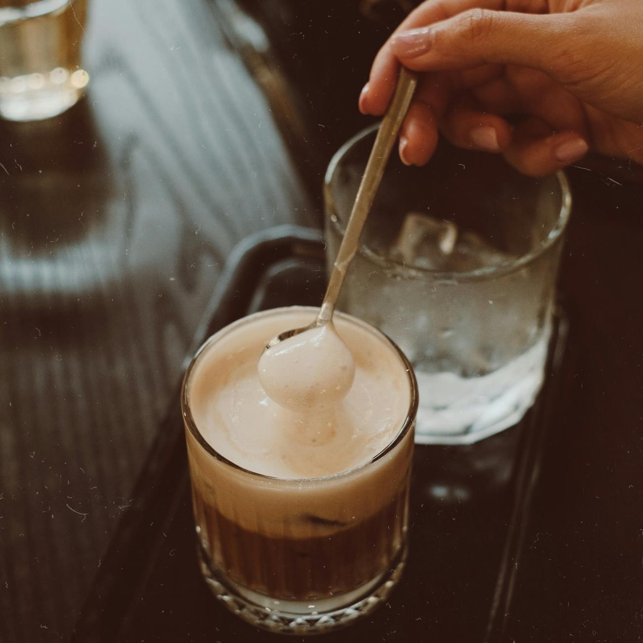 close up of coffee with cream being stirred
