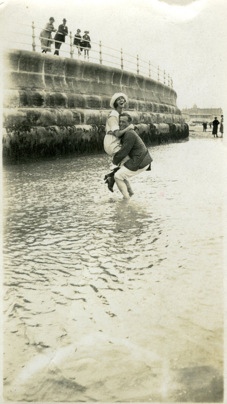monochrome photo of man carrying a woman