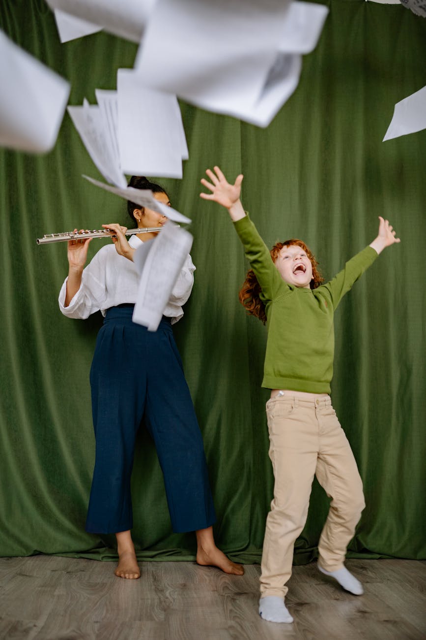 child celebrating next to a woman playing the flute