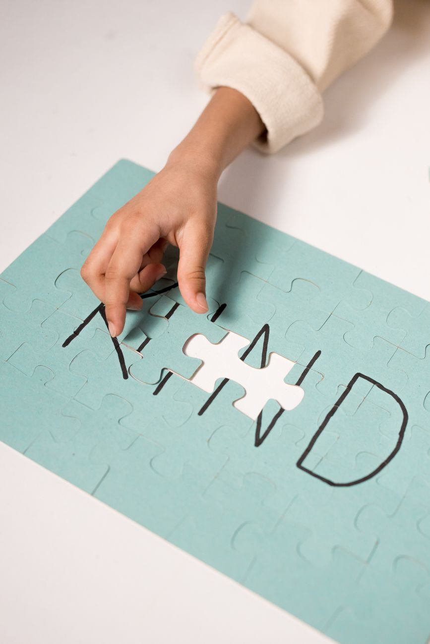 a person s hand solving a jigsaw puzzle
