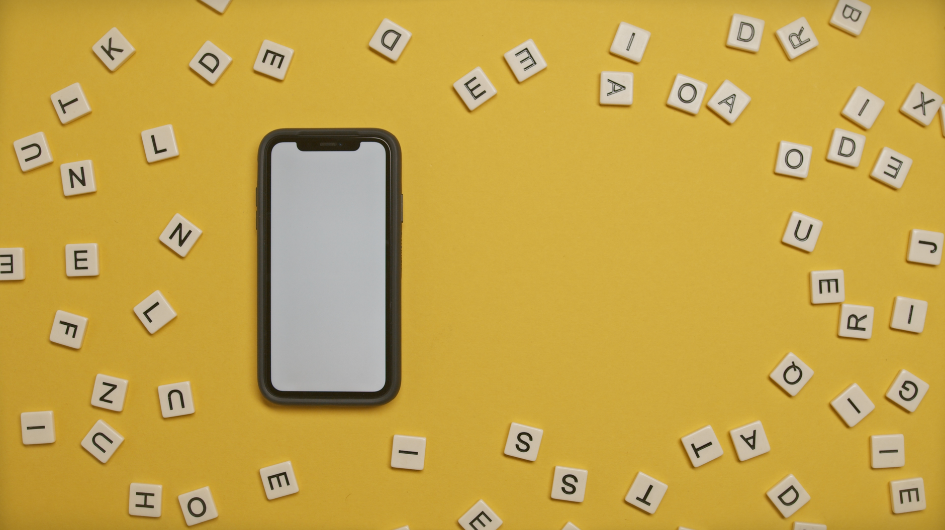 white and black smartphone on yellow surface
